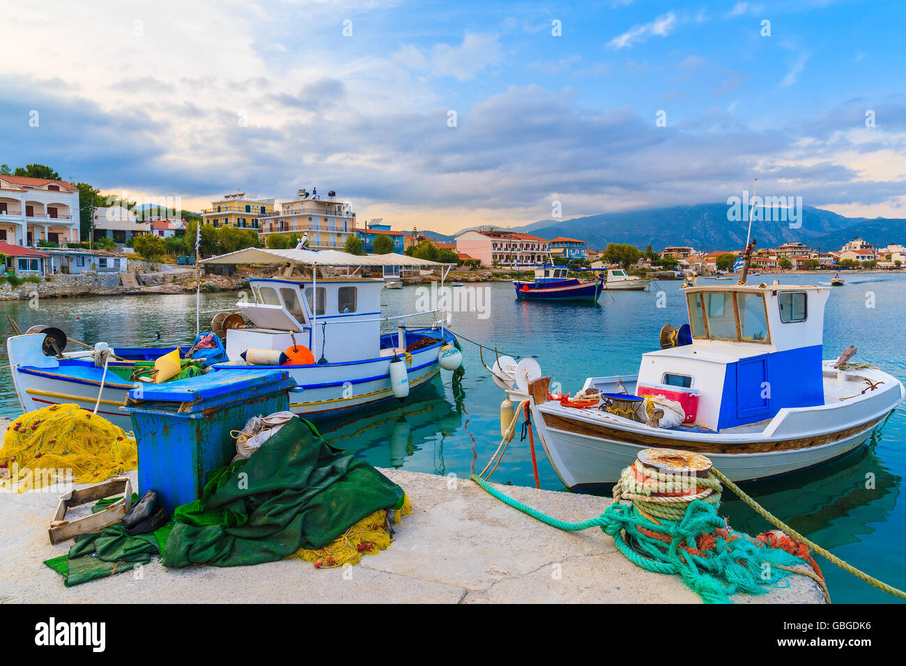Colourful Greek fishing boats mooring in port at sunset time on Samos island, Greece Stock Photo