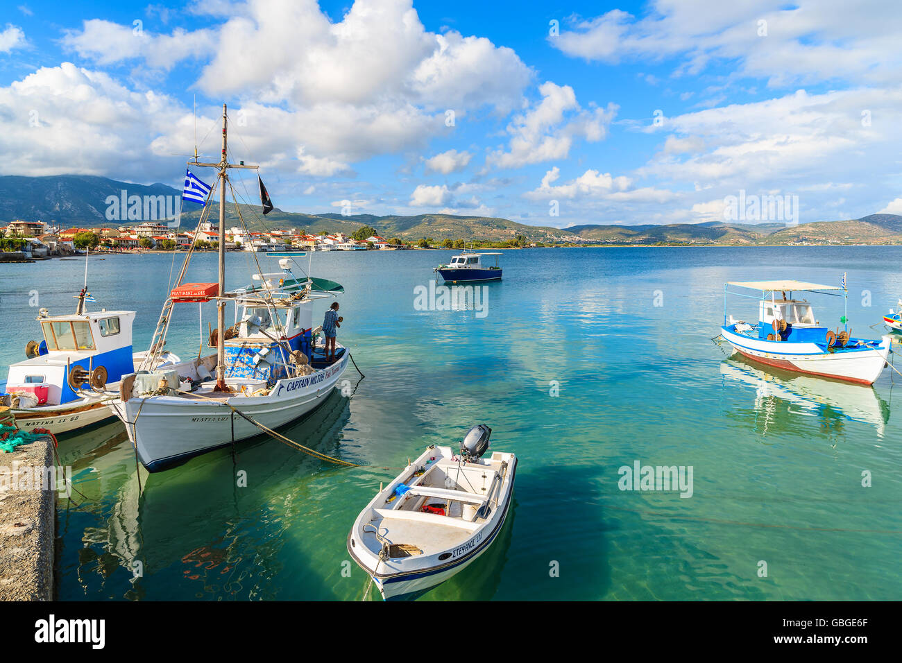 SAMOS ISLAND, GREECE - SEP 23, 2015: fisherman standing on Greek fishing boat mooring in port on Samos island, Greece. Stock Photo