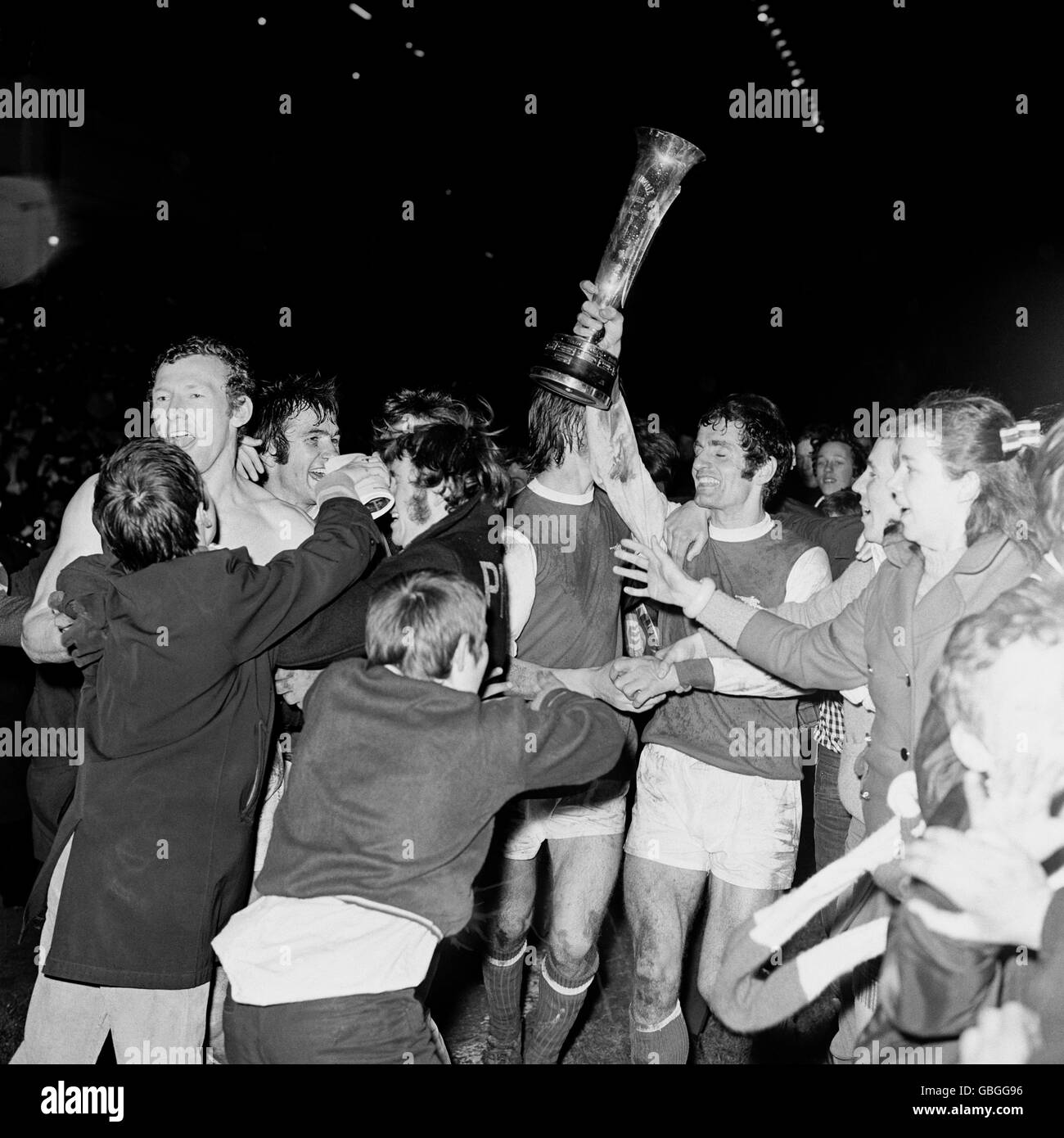Arsenal's Frank McLintock holds the trophy aloft as he and his teammates are mobbed by ecstatic fans during their lap of honour Stock Photo