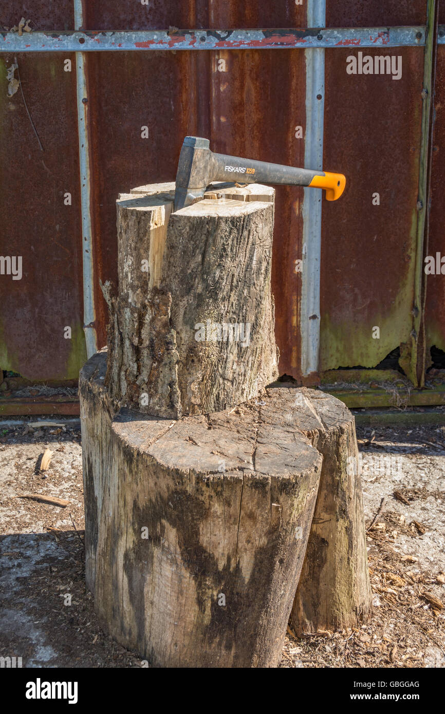 Wood being split with a splitting maul for firewood Stock Photo