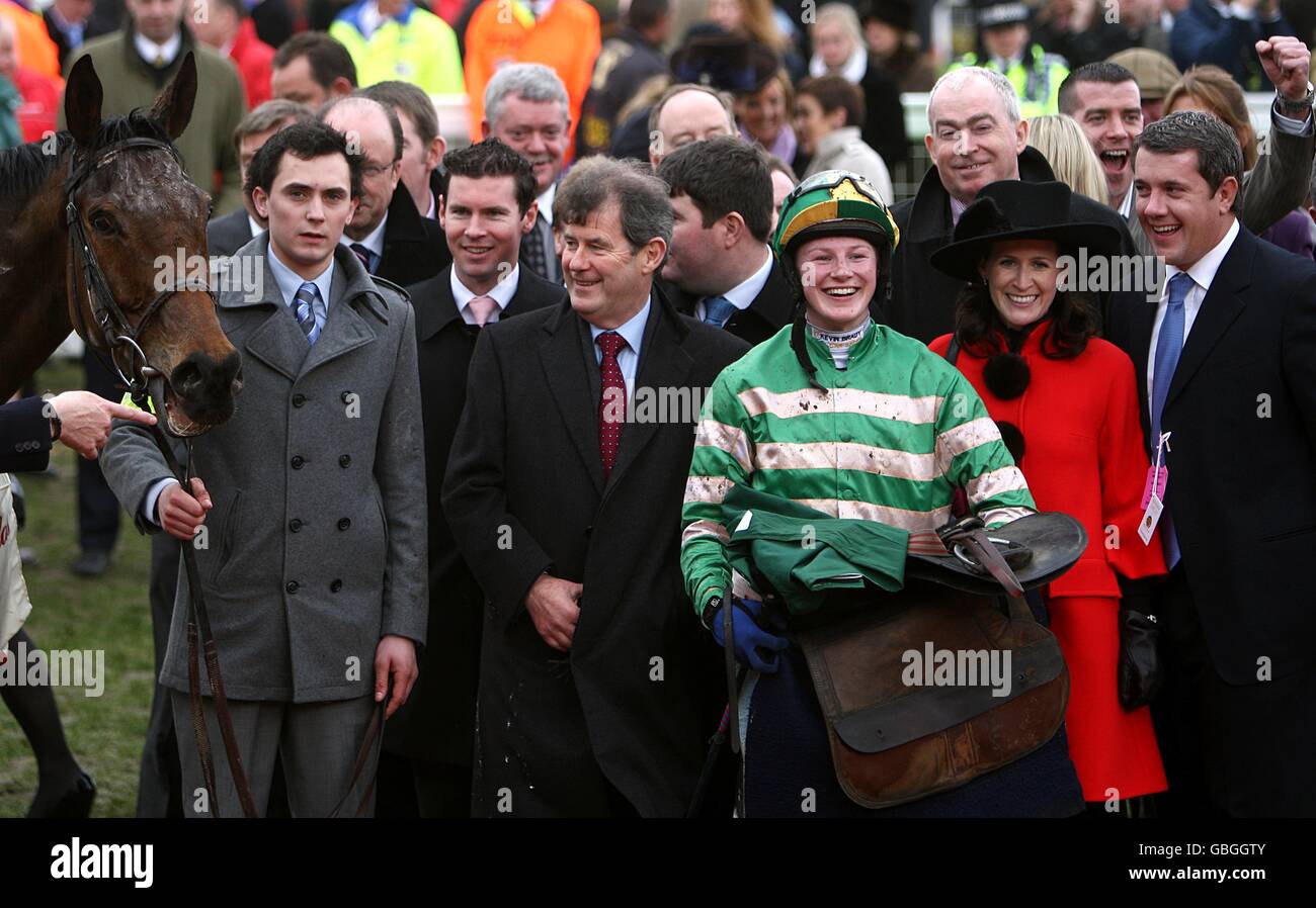 Jockey Nina Carberry (right from centre) with owner John P. McManus (centre) celerbate after winning the Glenfarclas Handicap Chase (Cross Country Chase). Stock Photo