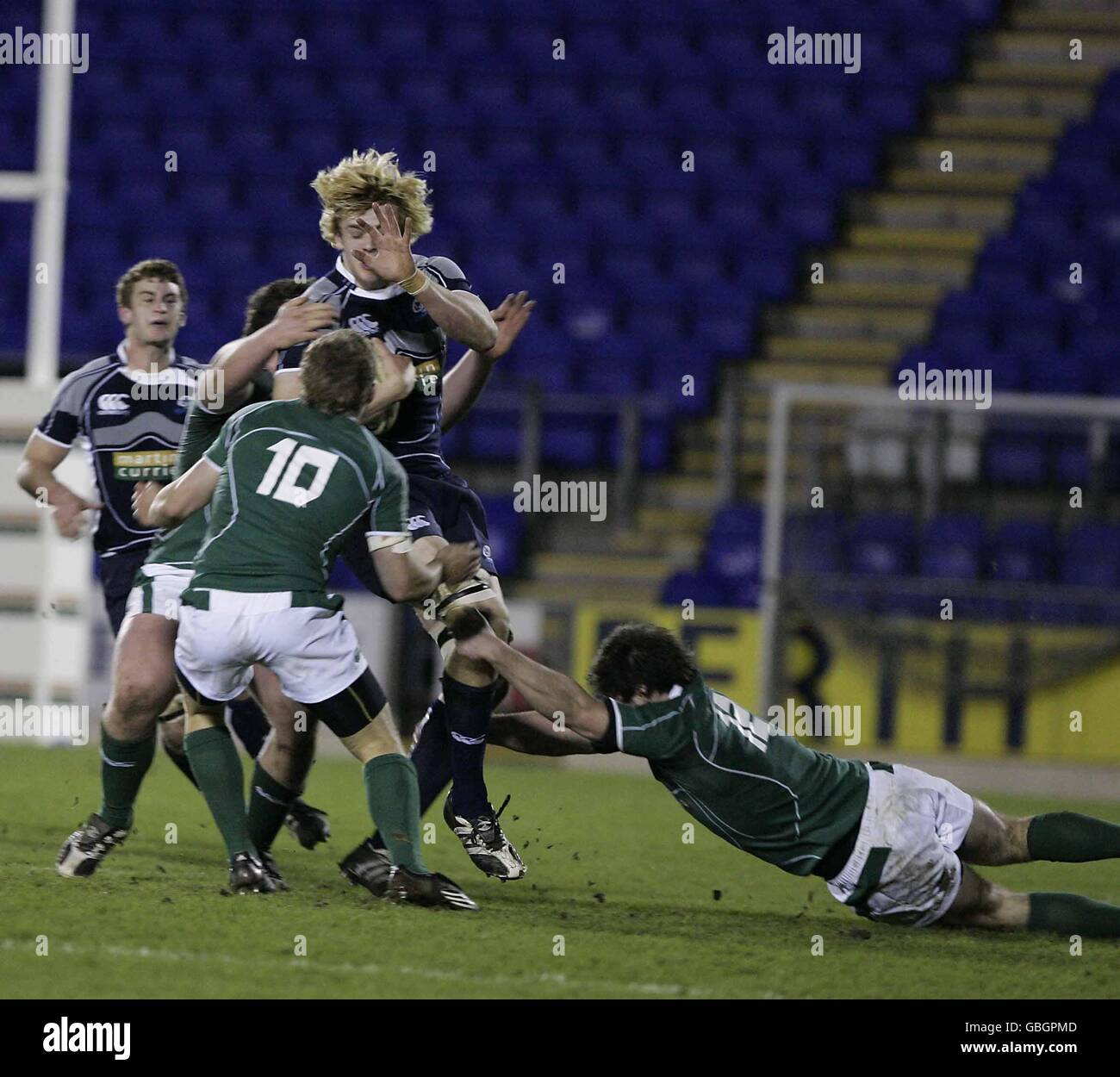 Scotland's Richard Gray (blonde hair) is tackled by Ireland's Ian Madigan (number 10) and Eamonn Sheridan (right) during the Under 20 match at McDiarmid Park, Perth Stock Photo