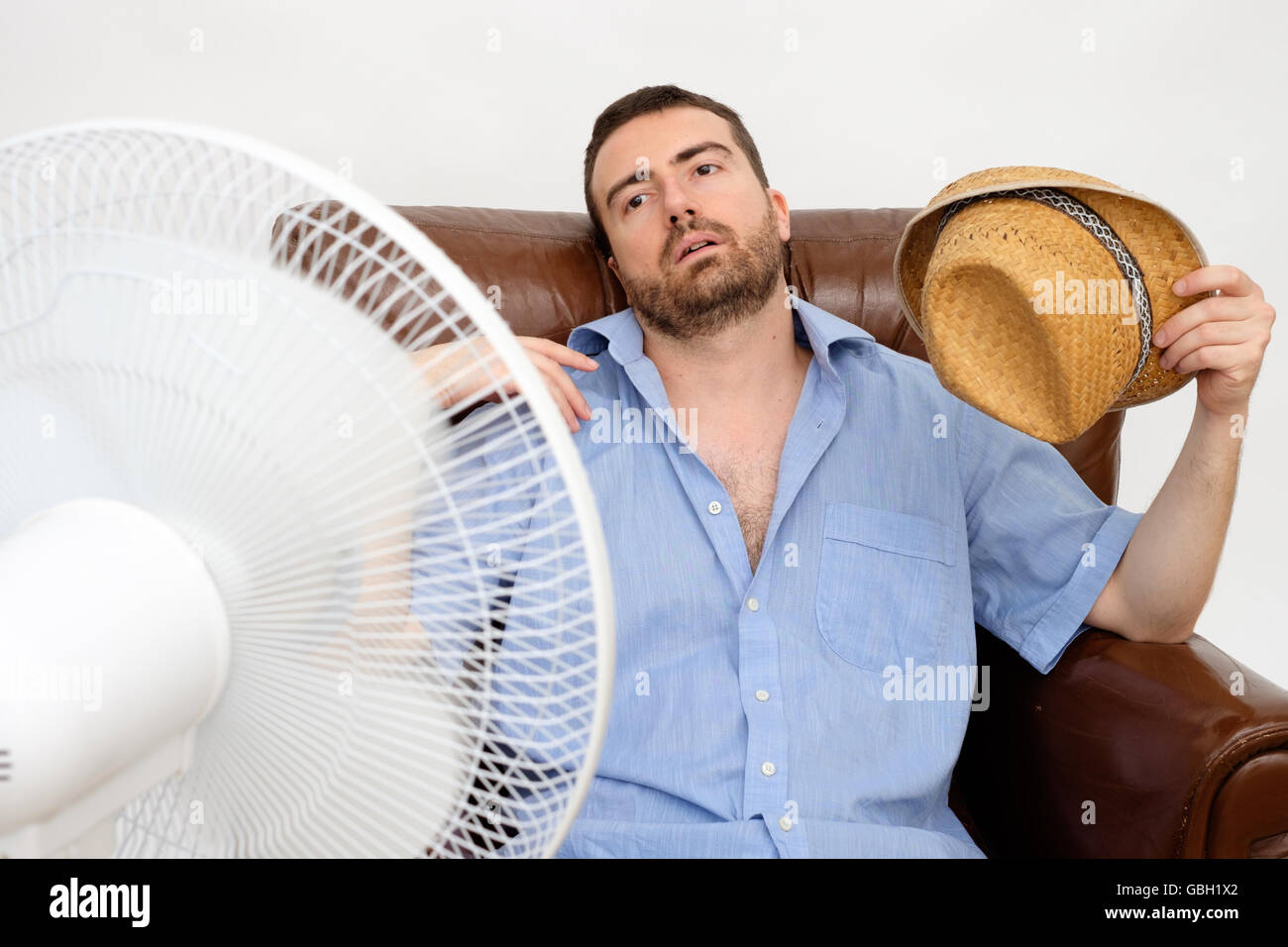 Flushed man feeling hot in front of a fan Stock Photo Alamy