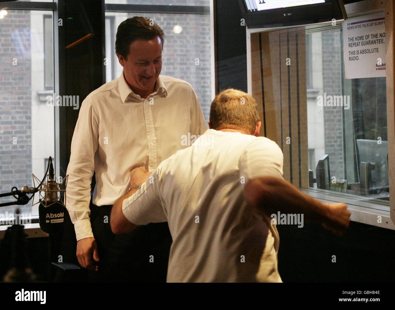 Conservative Leader David Cameron (left) with James Bond stuntman Derek Lea, during his guest appearance on the Breakfast Show with Christian O'Connell, at Absolute Radio in central London. Stock Photo