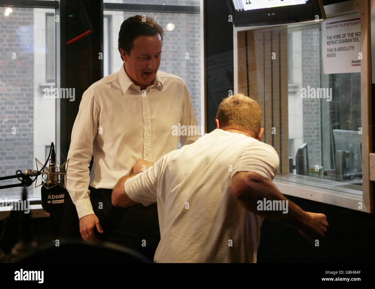 Conservative Leader David Cameron (left) with James Bond stuntman Derek Lea, during his guest appearance on the Breakfast Show with Christian O'Connell, at Absolute Radio in central London. Stock Photo