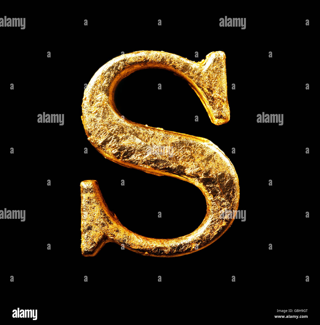 Alphabet and numbers in gold leaf isolated on black Stock Photo