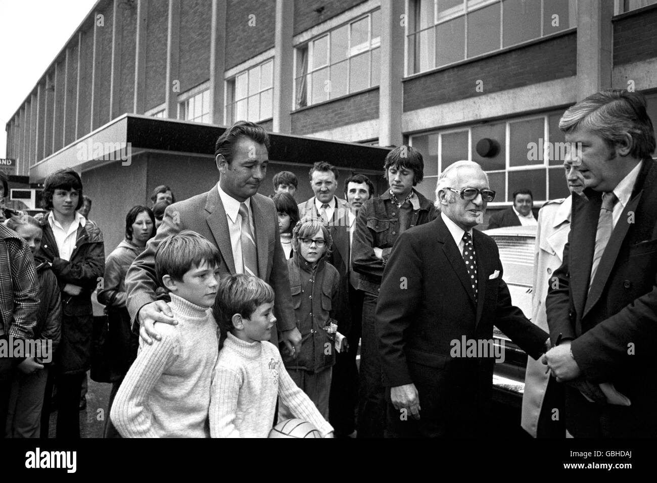 Leeds United chairman Manny Cussins (r) outside Elland road with the new Manager Brian Clough. Also pictured are Brian Clough's sons Nigel (then aged 8) and Simon (aged 10) Stock Photo