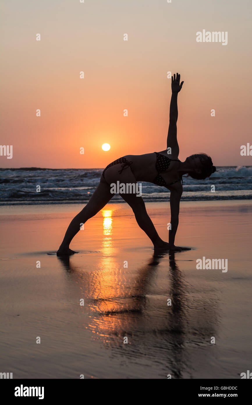 Silhouette of woman practicing yoga on the beach Stock Photo - Alamy