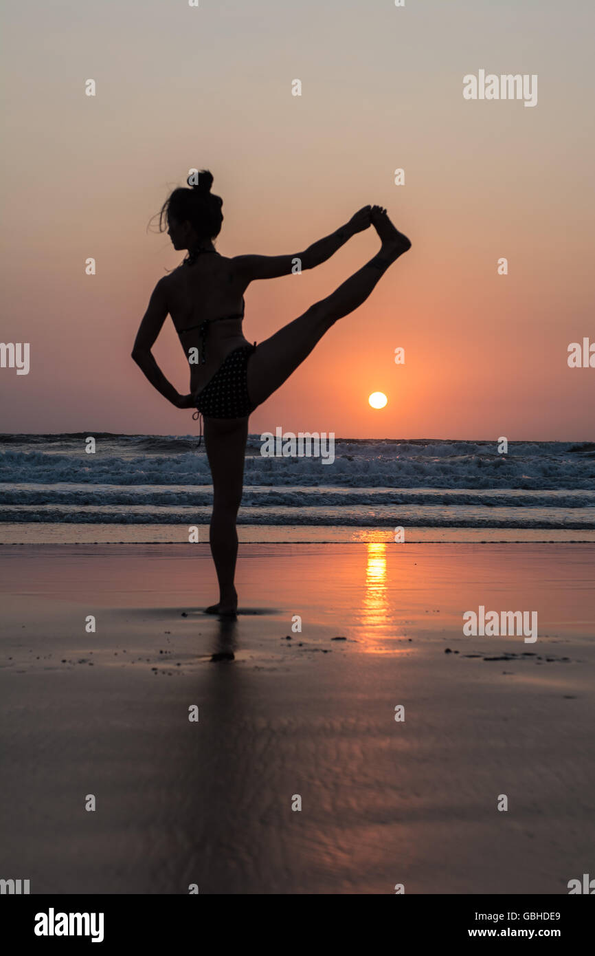 Silhouette of woman practicing yoga on the beach Stock Photo - Alamy