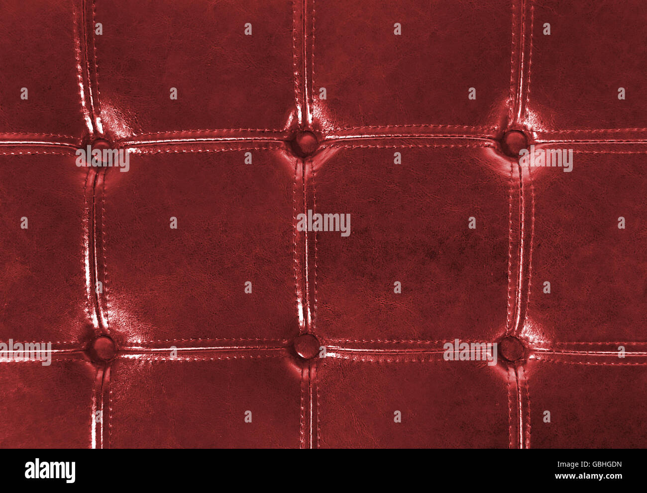 Close up of red tufter leather upholstery with buttons. Stock Photo