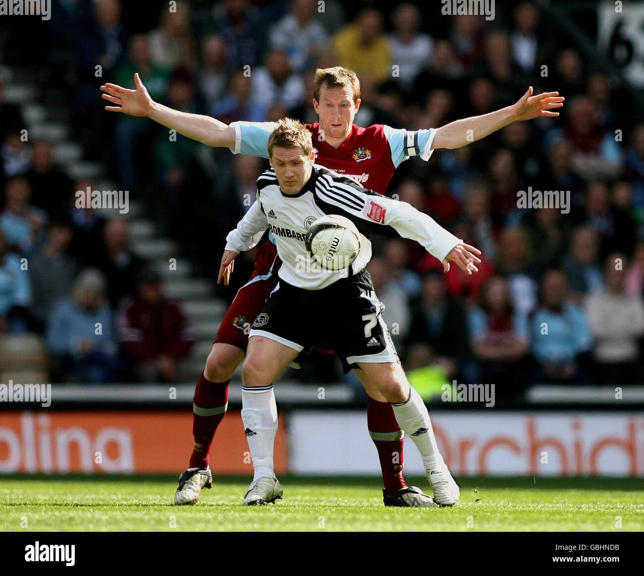 Derby County's Kris Commons (front) and Burnley's Stephen Caldwell (back) battle for the ball during the Coca-Cola Championship match at Pride Park, Derby. Stock Photo