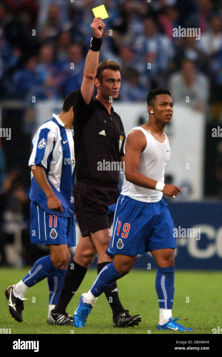 Referee Kim Milton Nielsen shows the yellow card the FC Porto goalscorer Carlos Alberto for removing his shirt during his celebration Stock Photo