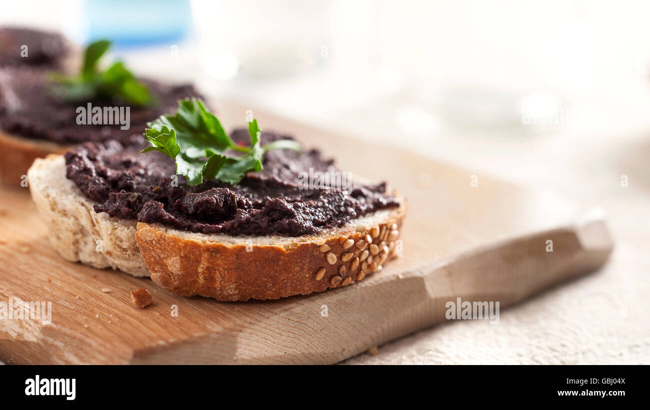 Olive tapenade on a slice of bread Stock Photo Alamy