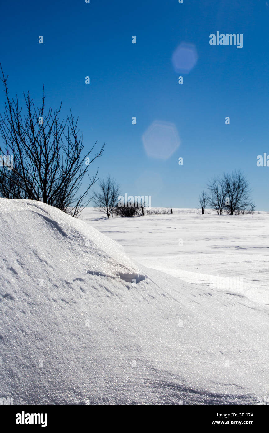 Heavy drifted snow after a snowstorm with blue skies. Stock Photo