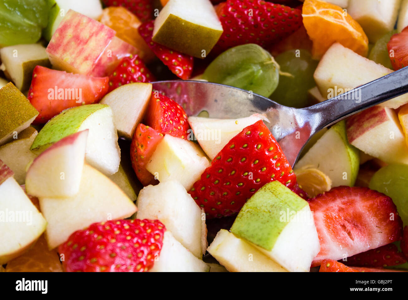 A colorful mix of fruit salad including strawberries, grapes, green