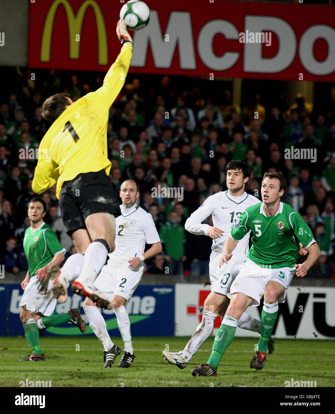 Northen Ireland's Jonny Evans is beaten to the ball by Slovenia goal keeper Jasmin Handanovic during the World Cup Qualifying match at Windsor Park, Belfast. Stock Photo