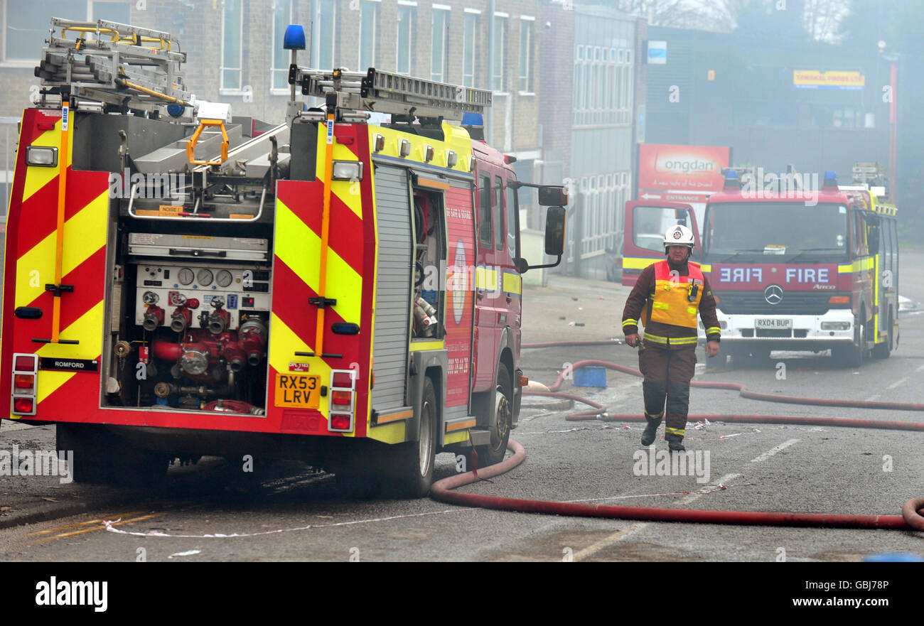 A fireman walks near the scene of a fire at a series of warehouses and ...