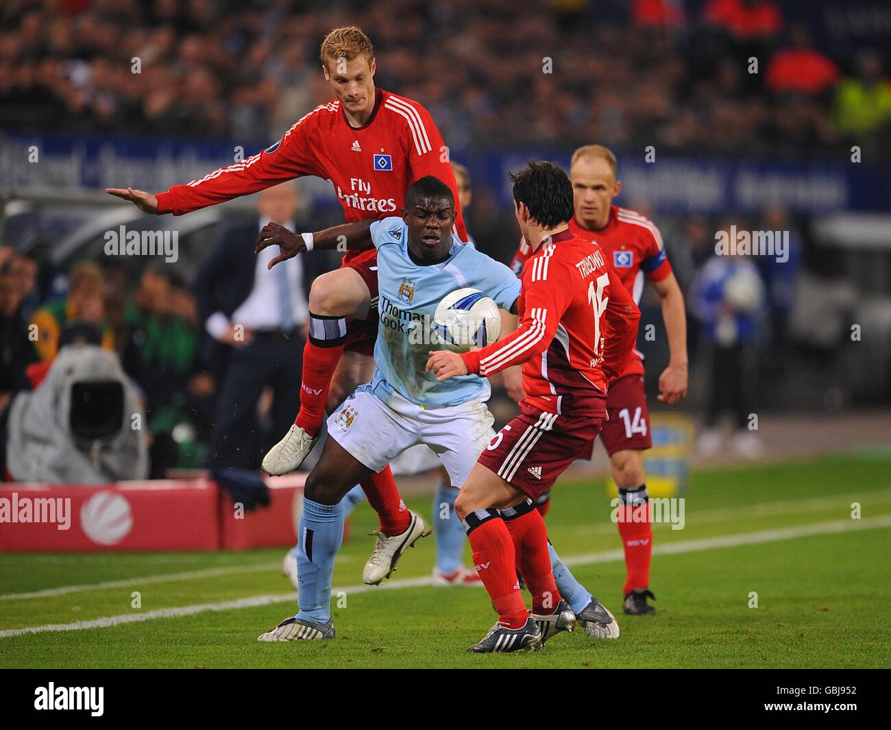 Manchester City's Micah Richards (centre) battles for the ball with Hamburg's Marcell Jansen (behind) and Piotr Trochowski(front right) Stock Photo