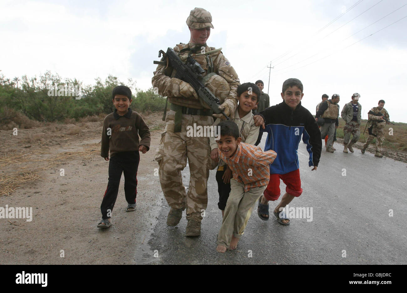RFM Ruff from Plymouth plays with kids on Leaf Island, Basra province, in the course of an operation to hunt out insurgents who fire rockets into the camp at Basra air base. Stock Photo