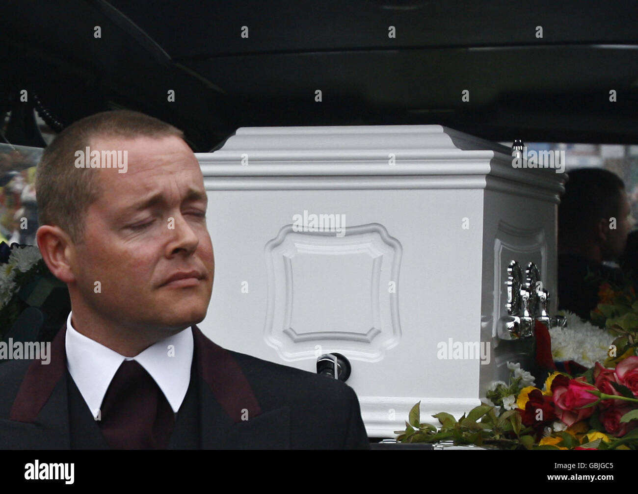 A pallbearer stands in front of the coffin as Jade Goody's funeral procession makes its way through Bermondsey in south-east London, during its journey to St John the Baptist Church in Essex, where the funeral will take place. Stock Photo