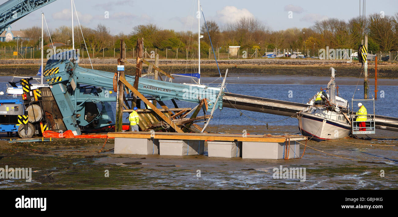 Salvage workers attempt to recover a crane which toppled over crushing a new 20,000 yacht at Portchester near Portsmouth. Stock Photo