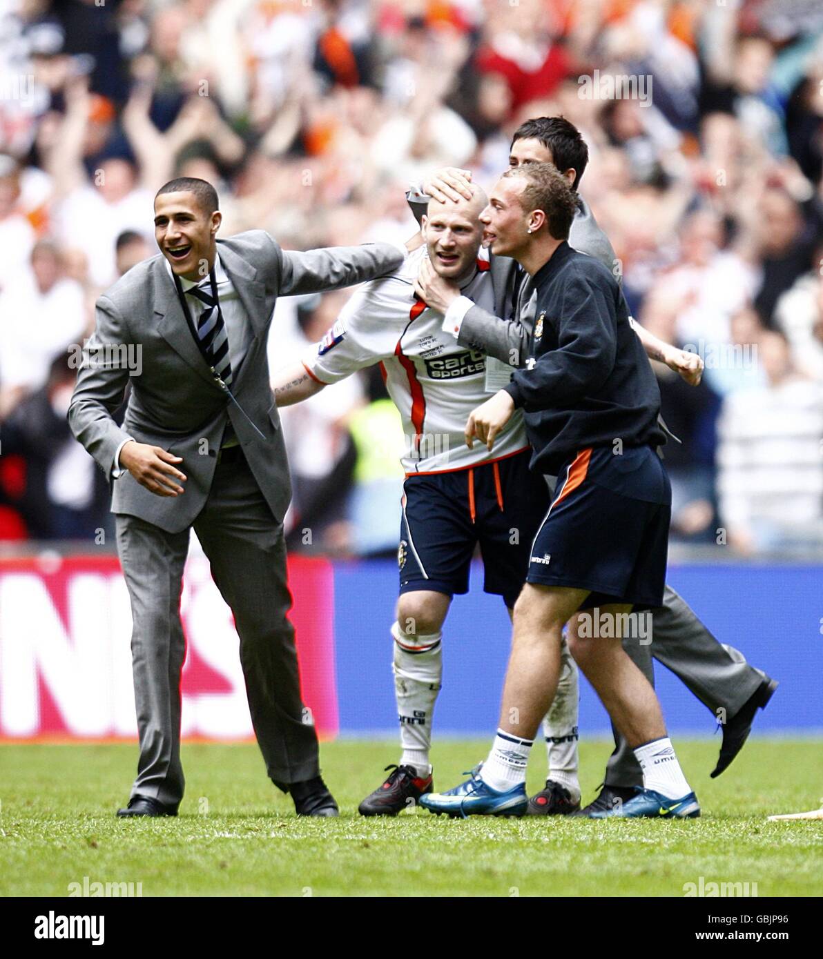 Luton Town captain Kevin Nicholls (center) is mobbed by teammates after