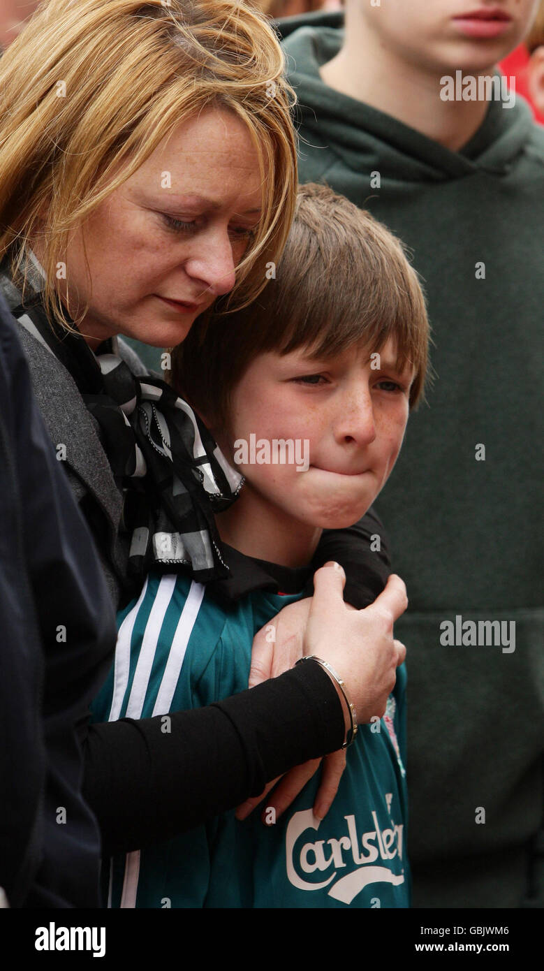 Fans stand in silence outside Anfield before the official memorial