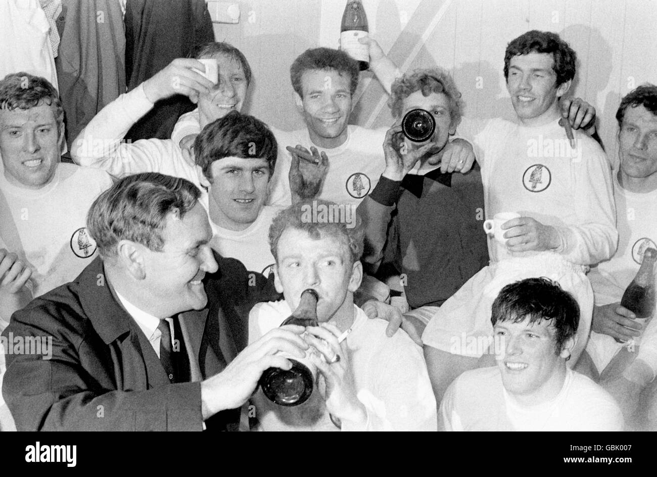 Leeds United players celebrate with champagne and cigars in the dressing room after drawing 0-0 with Liverpool, a result which wrapped up Leeds' first Division One Championship title: (back row, l-r) Mick Jones, Jack Charlton, Paul Reaney, Gary Sprake, Johnny Giles, Paul Madeley; (front row, l-r) manager Don Revie, Peter Lorimer, Billy Bremner, Eddie Gray Stock Photo