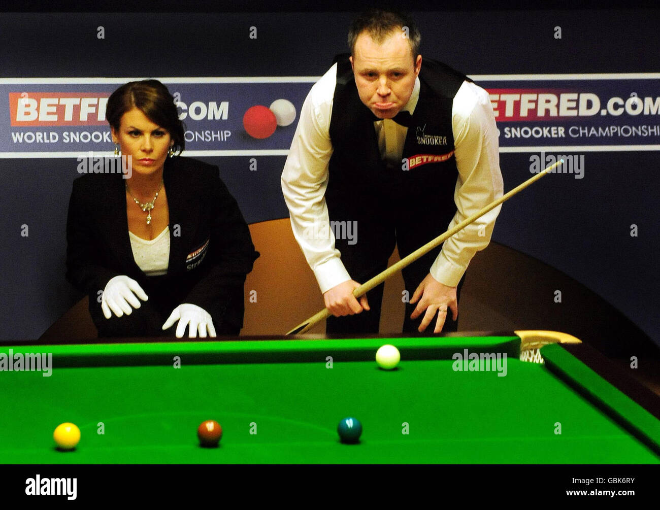 Scotland's John Higgins (right) with referee Michaela Tabb during the Final of the Betfred.com World Snooker Championship at The Crucible Theatre, Sheffield. Stock Photo