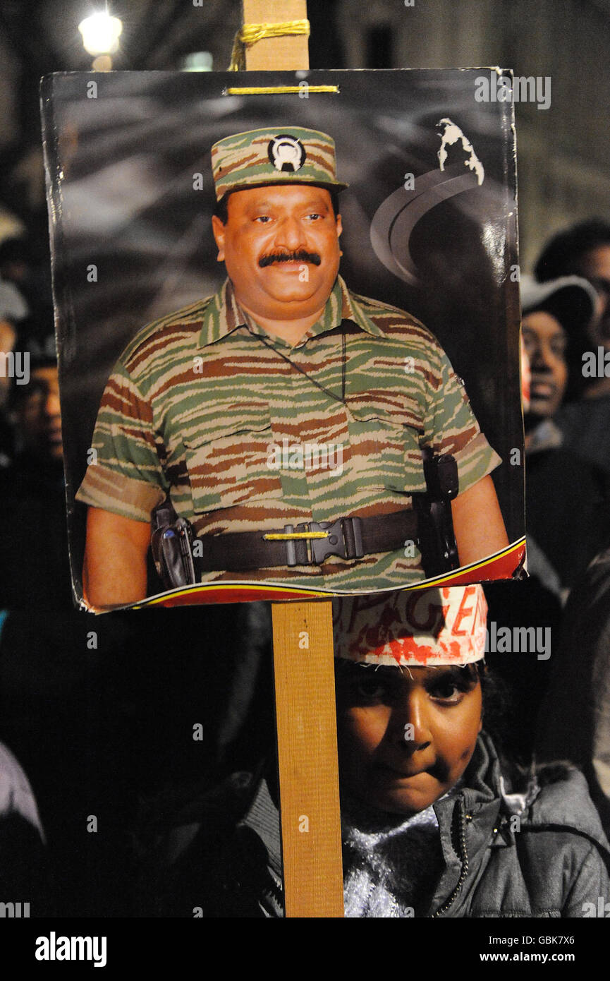 A girl with a portrait of Tamil Tiger leader, Velupillai Prabhakaran, watching over Prarameswaran Subramaniam, 28, and Sivatharsan Sivakumaraval, 21, students from Mitcham in south London, who are on on hunger strike in London's Parliament Square where a protest by around 500 Tamil has entered its fifth day. Stock Photo