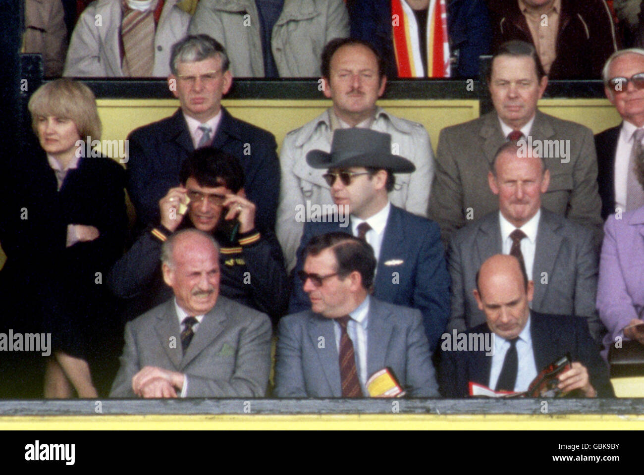 Watford Chairman Elton John (c) sits in the directors' box between Manager Graham Taylor (l) and General Manager Bertie Mee (r) Stock Photo