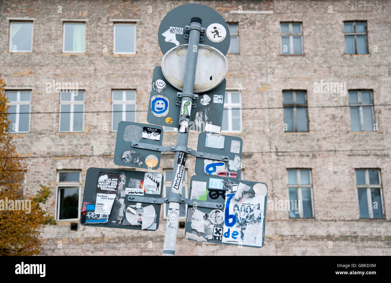Road signs seen from behind with stickers in front of the facade of a building on Oranienburgerstrasse, Berlin Stock Photo