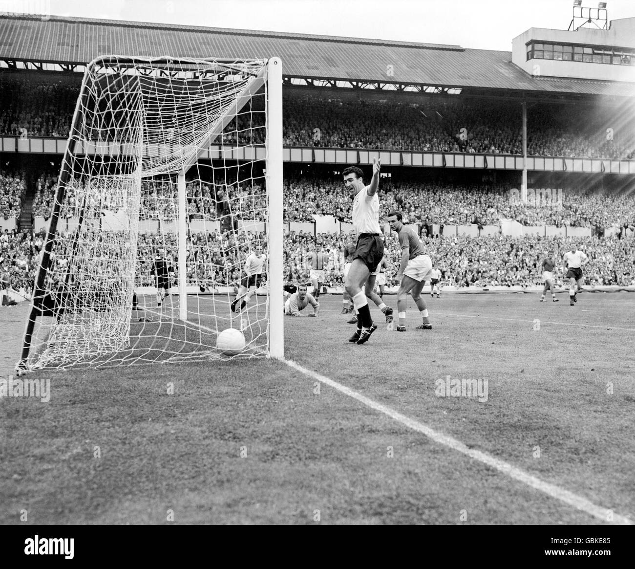 Tottenham Hotspur's Bobby Smith (c) celebrates as a shot from teammate Les Allen (l) beats FA Select XI goalkeeper Ron Springett (second l) for a goal, watched by FA Select XI's Ron Flowers (half hidden by Smith), Jimmy Armfield (r) and Bobby Robson (behind Springett) Stock Photo