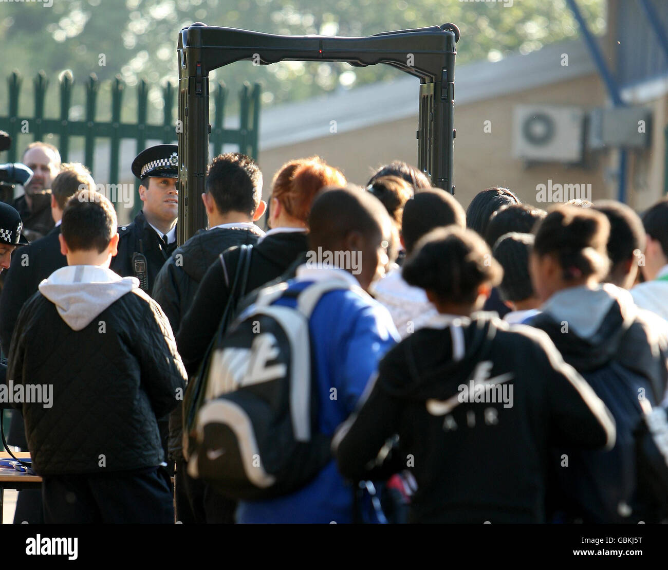 Pupils at Lammas School and Sports College in Leyton, east London, queue to pass through a metal detector at the school entrance. Stock Photo