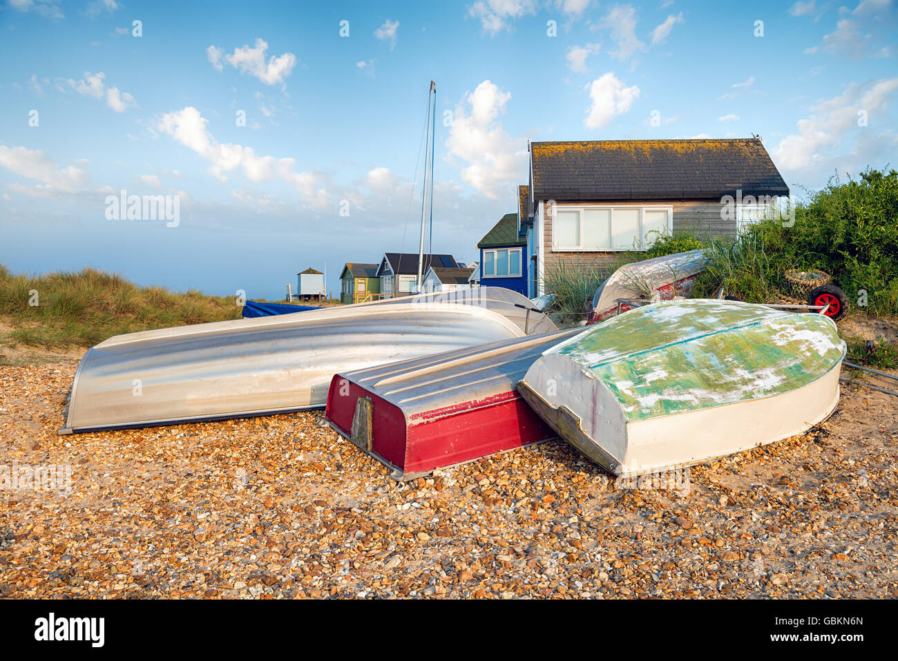 Boats and beach huts at Mudeford Spit at Christchurch on the Dorset coast Stock Photo