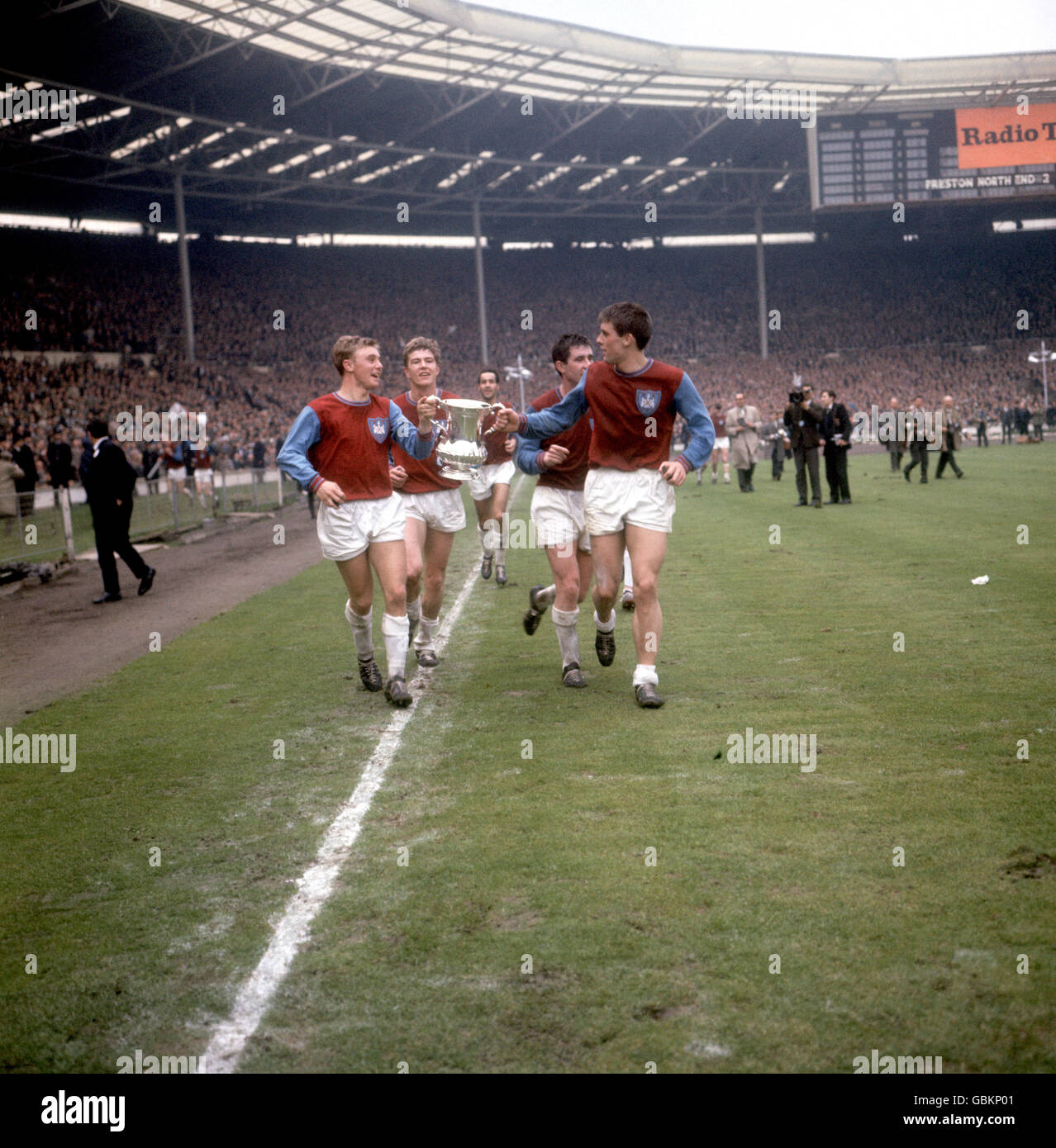 West Ham United's John Sissons (l) and Geoff Hurst (r) parade the FA Cup around Wembley with teammates Jack Birkett (second l), Eddie Bovington (c) and Ronnie Boyce (second r) Stock Photo