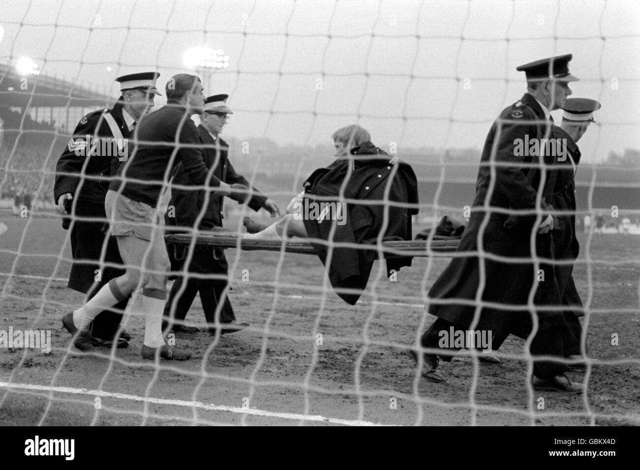 Real Zaragoza goalkeeper Enrique Yarza (l) offers his commiserations as Leeds United's Jimmy Greenhoff, draped in a St John's Ambulance greatcoat, is stretchered off with an ankle injury Stock Photo