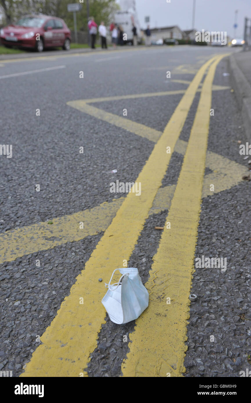A disused medical face mask lays on the road outside Downend School technology college, South Gloucestershire, where a 12 year old girl has a confirmed case of swine flu. Stock Photo