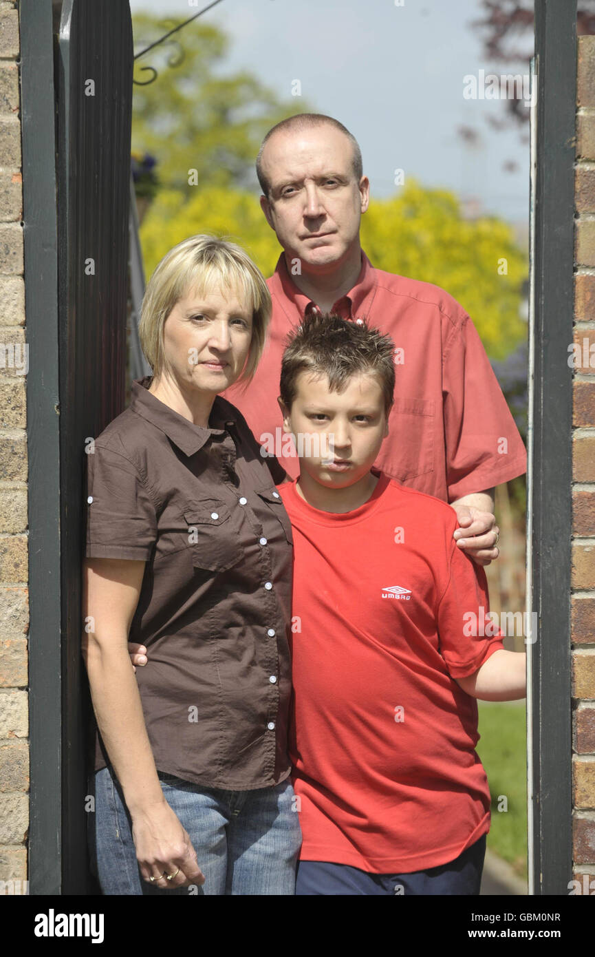 Barry Greatorex, 43, from Chipping Sodbury, in South Gloucestershire, stands at his garden gate with his wife Fran, 46, and son Jamie, 13, as he is stuck at home under quarantine with a confirmed case of swine flu. Stock Photo