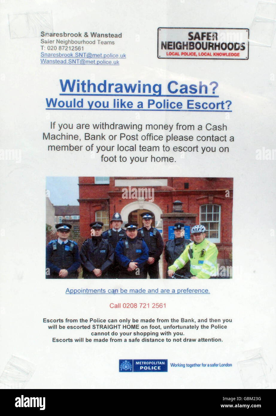 Photo of police poster in a shop window in Wanstead that offers a police escort home from the bank. Stock Photo
