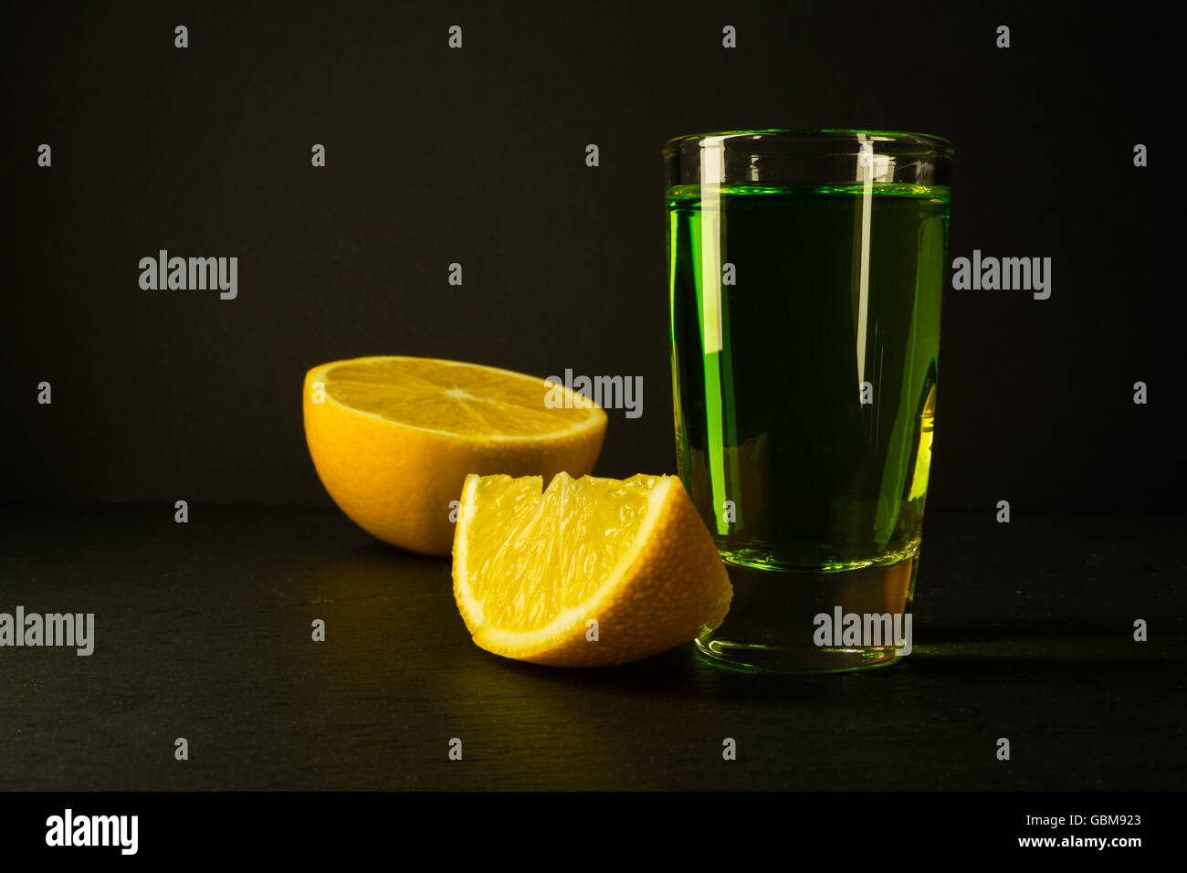 Absinthe and lime on black background. Alcohol drink. Green alcohol drink Stock Photo