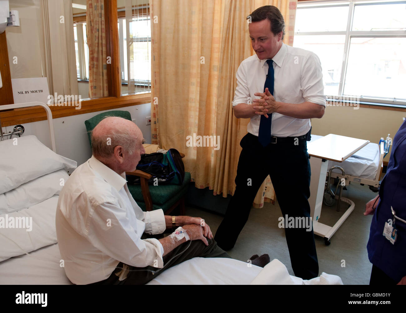 Conservative Party leader David Cameron talks to patient Phillip Lewis during a visit to Harrogate District Hospital. Stock Photo