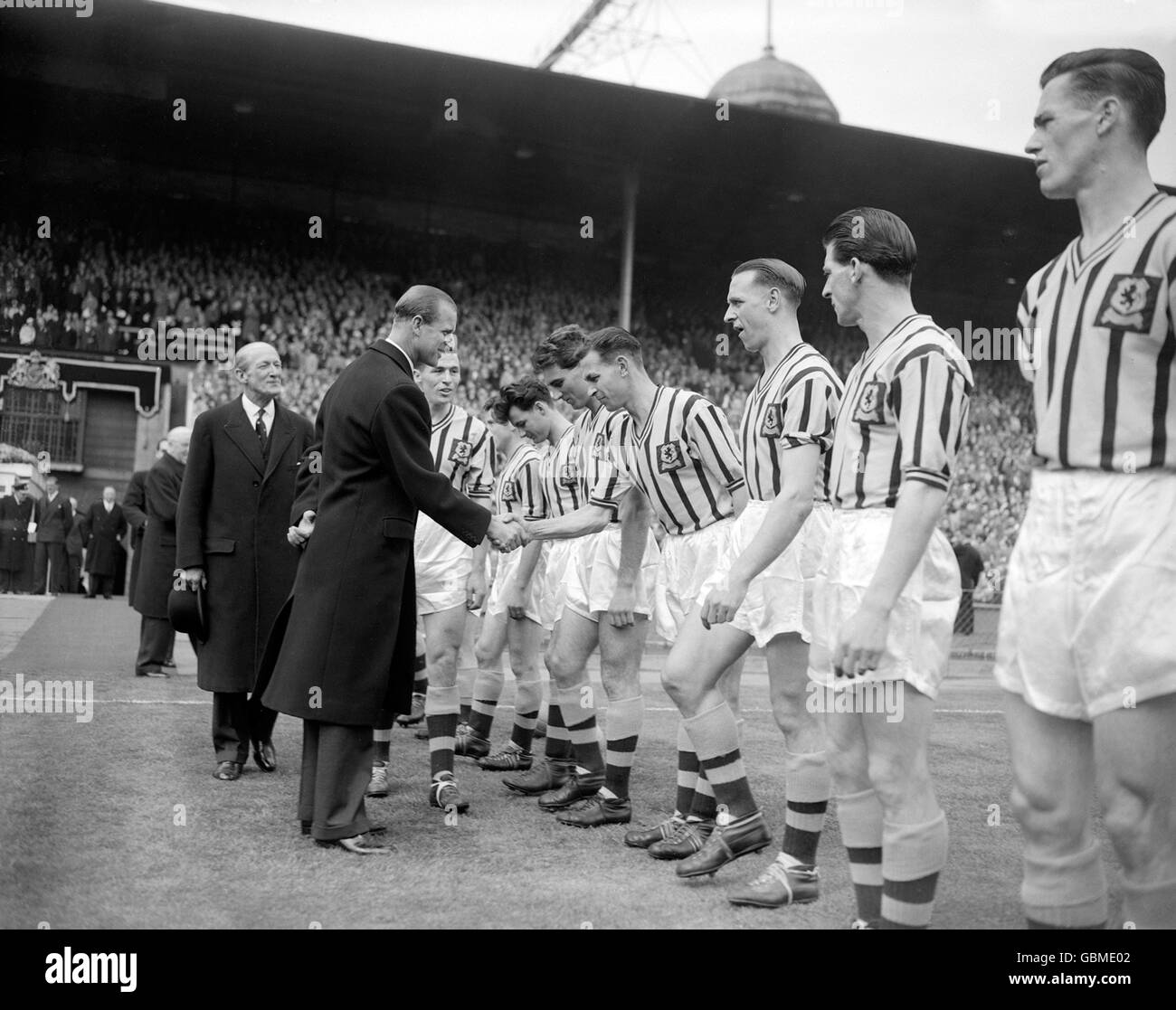HRH The Duke of Edinburgh shakes hands with Aston Villa's Peter Aldis (fourth r) as Villa captain Johnny Dixon (second l) presents his team before the match. The other Villa players are (r-l) Peter McParland, Bill Myerscough, Stan Lynn, Aldis, Pat Saward, Jimmy Dugdale Stock Photo