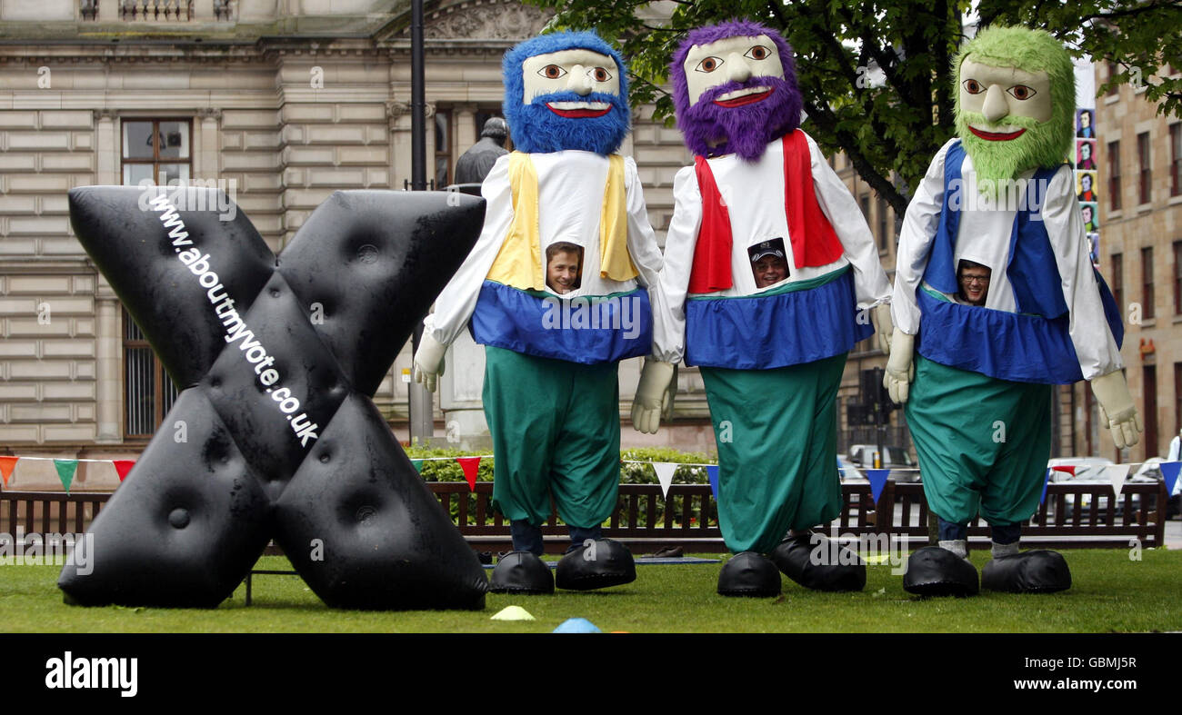(Left to right) John Edwards of the European Parliament Office in Scotland, David Miller, Election's Co-Ordinator for Glasgow City Council and Andy O'Neill, Head of Electoral Commission in Scotland, take part in an 'It's a Knockout' event in Glasgow's George Square to launch Register to Vote Week. Stock Photo