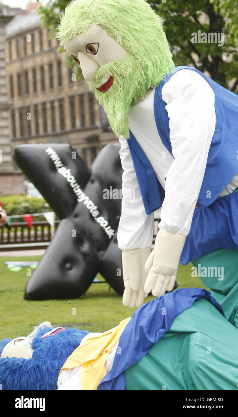 John Edward (on the ground ) of the European Parliament Office in Scotland, and Andy O'Neill (right), Head of Electoral Commission in Scotland, take part in an 'It's a Knockout' event in Glasgow's George Square to launch Register to Vote Week. Stock Photo