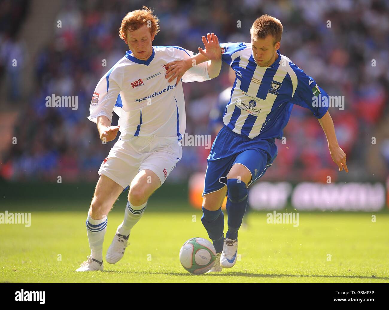 Glossop North End's Sam Hind (left) and Whiltey Bay's Chris Fawcett (right) in action Stock Photo