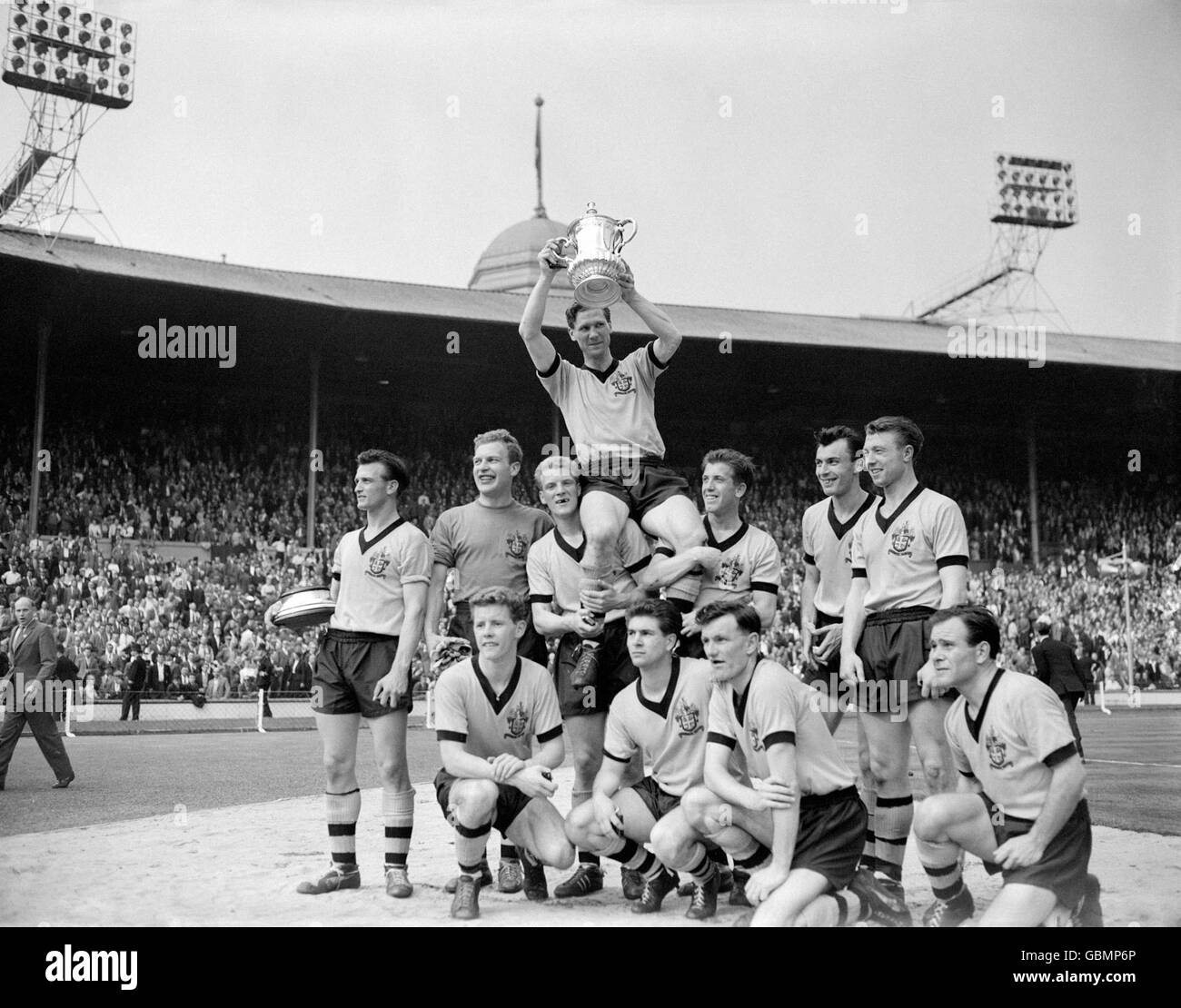 Wolverhampton Wanderers captain Bill Slater holds the FA Cup aloft as he is chaired by his jubilant teammates: (back row, l-r) Gerry Harris, Malcolm Finlayson, Ron Flowers, Peter Broadbent, Eddie Clamp, George Showell; (front row, l-r) Barry Stobart, Des Horne, Jimmy Murray, Norman Deeley Stock Photo