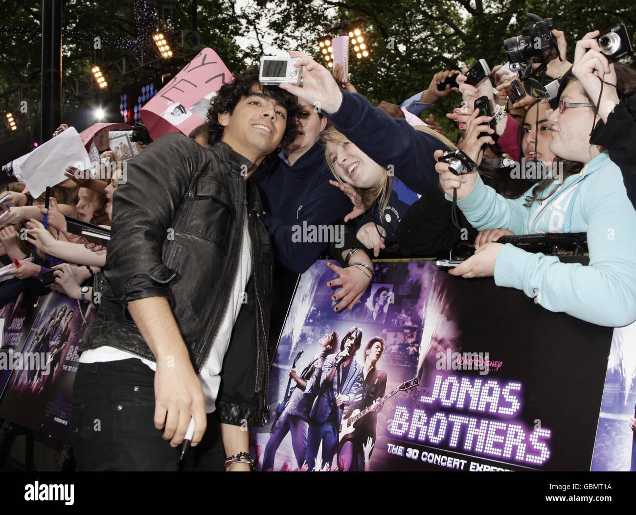 Nick Jonas poses for photos with fans before the premiere of 'Jonas Brothers: The 3D Concert Experience' at the Empire cinema in Leicester Square, London. Stock Photo