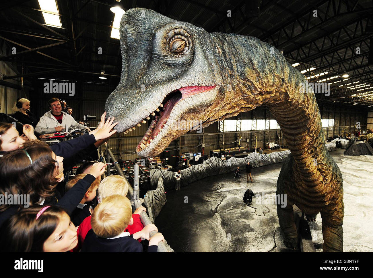 Children visiting the set of the Walking With Dinosaurs show at Tockwith, North Yorkshire, admire two Brachiosaurus animatronic models as they move around the set. Stock Photo