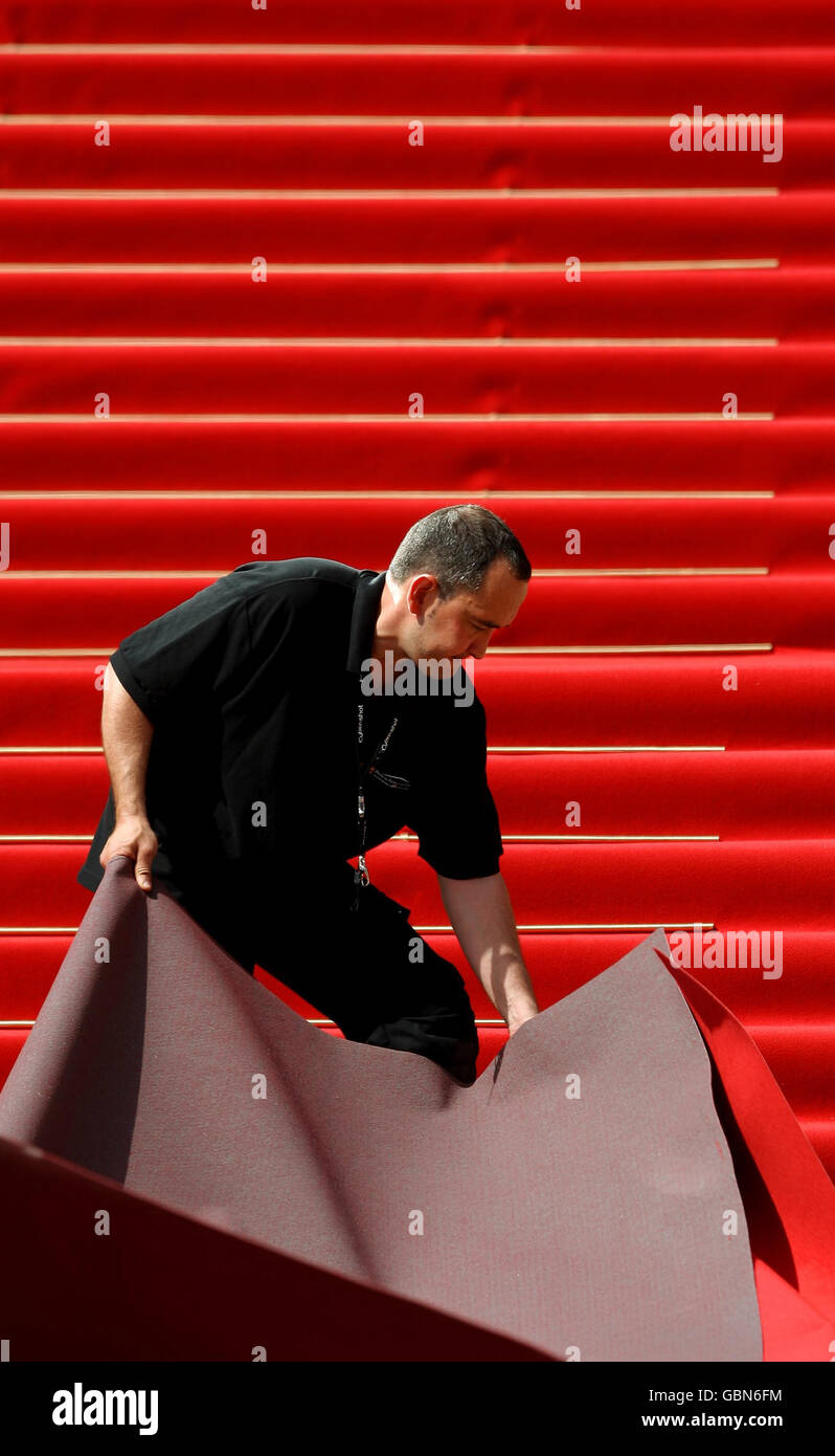 Workers prepare the red carpet on the steps of the Palais des Festivals, in Cannes, France, ahead of the start of the Festival de Cannes. Stock Photo